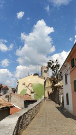 Street amidst buildings in town against sky