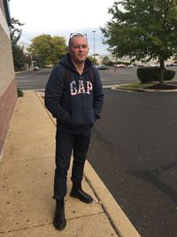 Portrait of young man standing on road