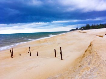 Scenic view of beach against cloudy sky