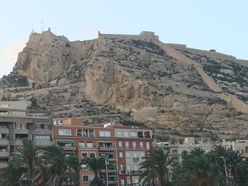 Low angle view of buildings and mountain against sky