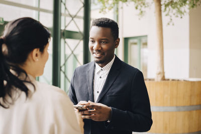 Businessman communicating with female coworker in meeting at office