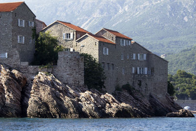 Houses by sea against mountain