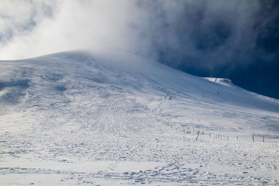 Scenic view of snow covered mountains against sky