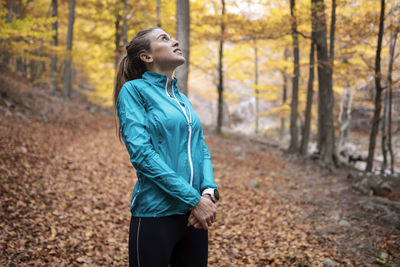 Side view of man running in forest during autumn