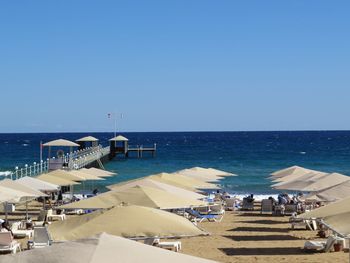 Scenic view of beach against clear blue sky