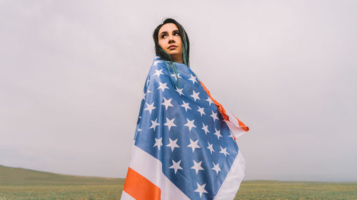 Portrait of a young woman standing on field