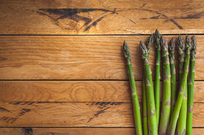 Fresh green asparagus on wooden background, top view, text space, copy space