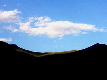 Scenic view of mountains against cloudy sky