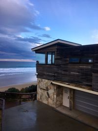 Built structure on beach by sea against sky