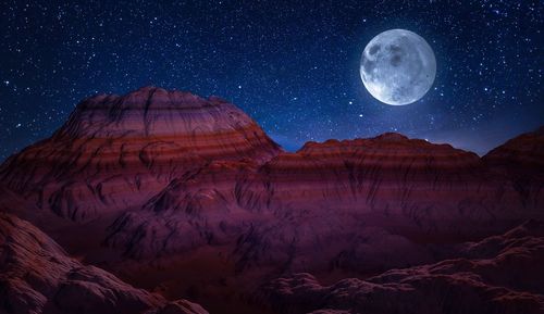 Scenic view of mountains against sky at night