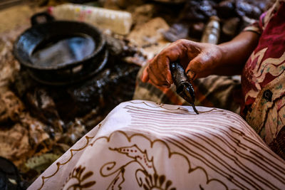 Midsection of woman painting fabric