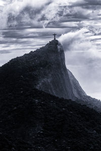 Man standing on cliff against sky