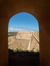 View of old ruin seen through arch window