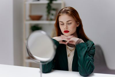 Portrait of young woman using mobile phone at home