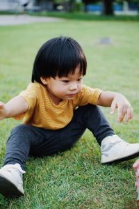 Portrait of boy sitting on field