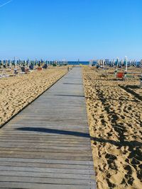 Scenic view of beach against clear blue sky