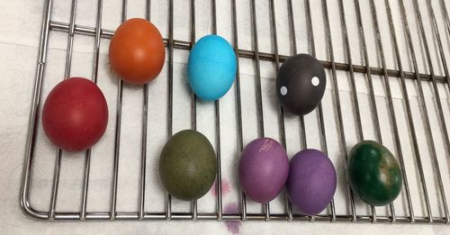 High angle view of colorful easter eggs on cooling rack at table