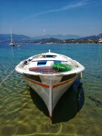 Boat moored on sea against blue sky