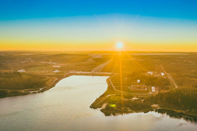 Aerial view of bridge over river against sky during sunset