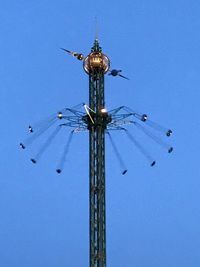 Low angle view of chain swing ride against clear blue sky