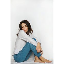 Young woman sitting against wall