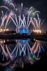 Firework display over river at night