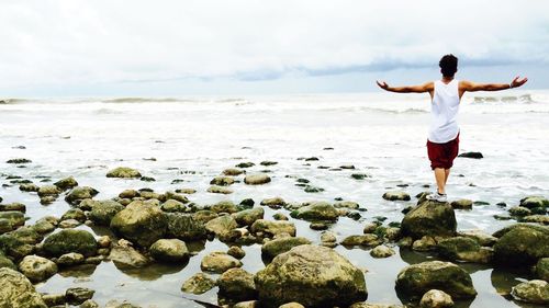 Rear view of woman standing on beach
