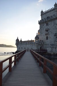 Bridge over river amidst buildings against sky