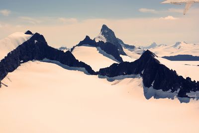 Scenic view of snowcapped mountains against sky during sunset