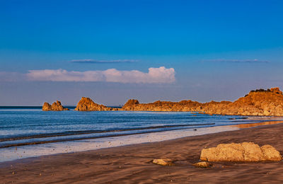 Scenic view of beach against blue sky