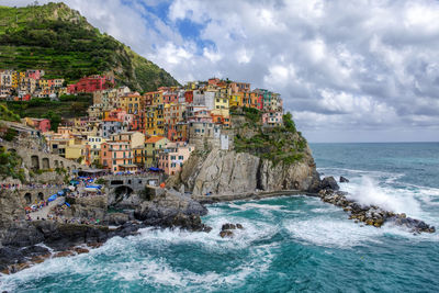 Scenic view of sea and buildings against sky at manarola