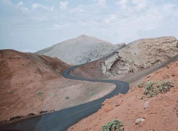 High angle view of road by mountains against sky