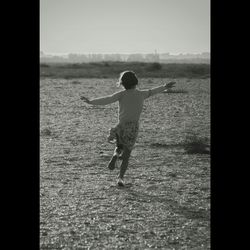 Rear view of boy playing in sea
