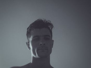 Close-up portrait of shirtless boy against white background