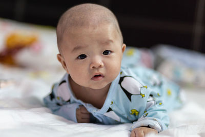 Portrait of cute baby lying on bed