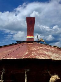 Low angle view of red ship against sky
