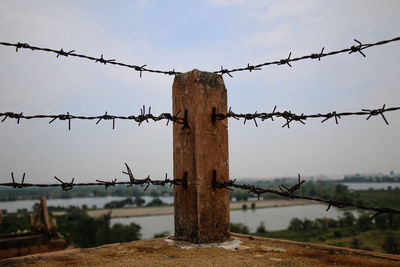 Barbed wire fence against sky