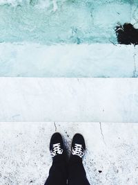 High angle view of person standing on steps by pond