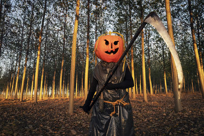 Rear view of woman standing against trees