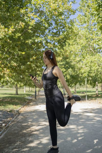 Portrait of young woman standing on road