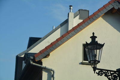 Low angle view of gas light and building against sky