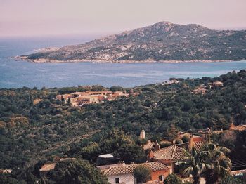 High angle view of townscape by sea against sky