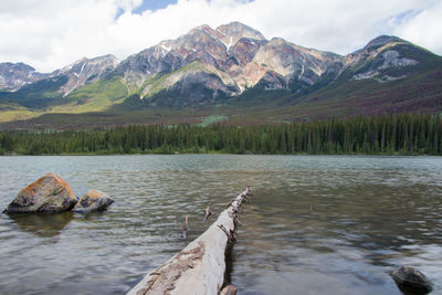 Scenic view of lake by mountains against sky