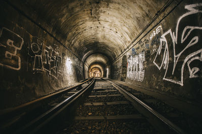 Railroad tracks in illuminated tunnel