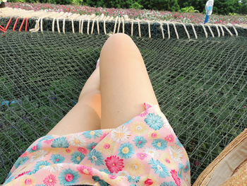 Low section of woman lying on swimming pool