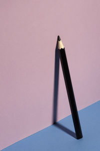 High angle view of pencil against pink wall