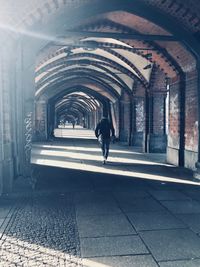 Rear view of man walking at railroad station platform