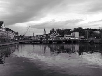 River in city against cloudy sky