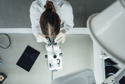 Young scientist working with microscope in laboratory