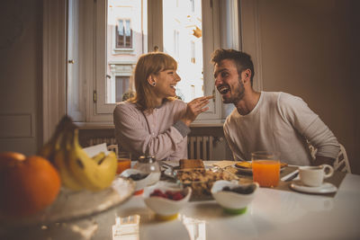 Friends sitting on table at home